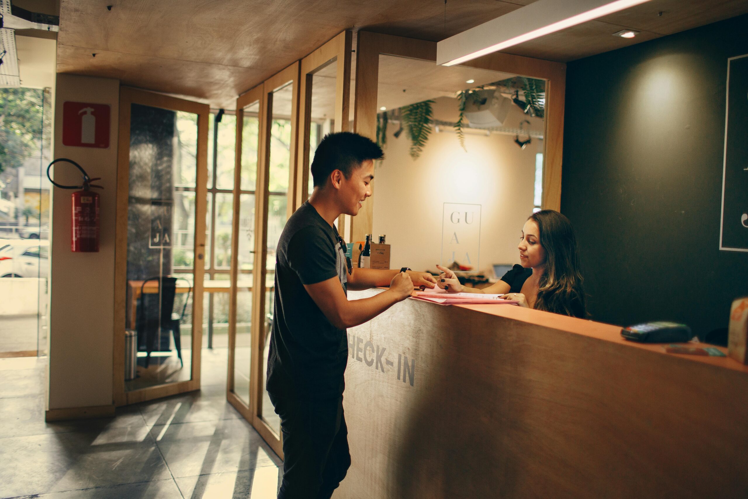 A customer checks in at a hotel reception desk.